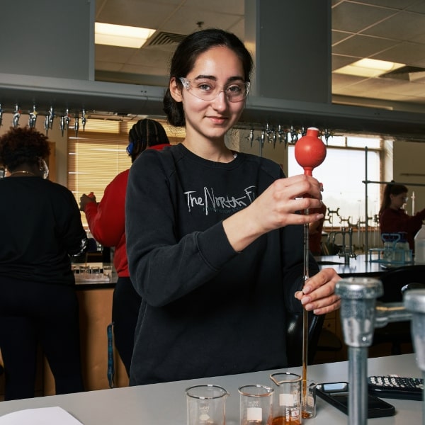 Student working with science lab equipment