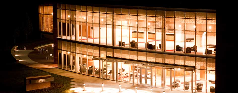 Photo of a MGA building at night with all the window lit up