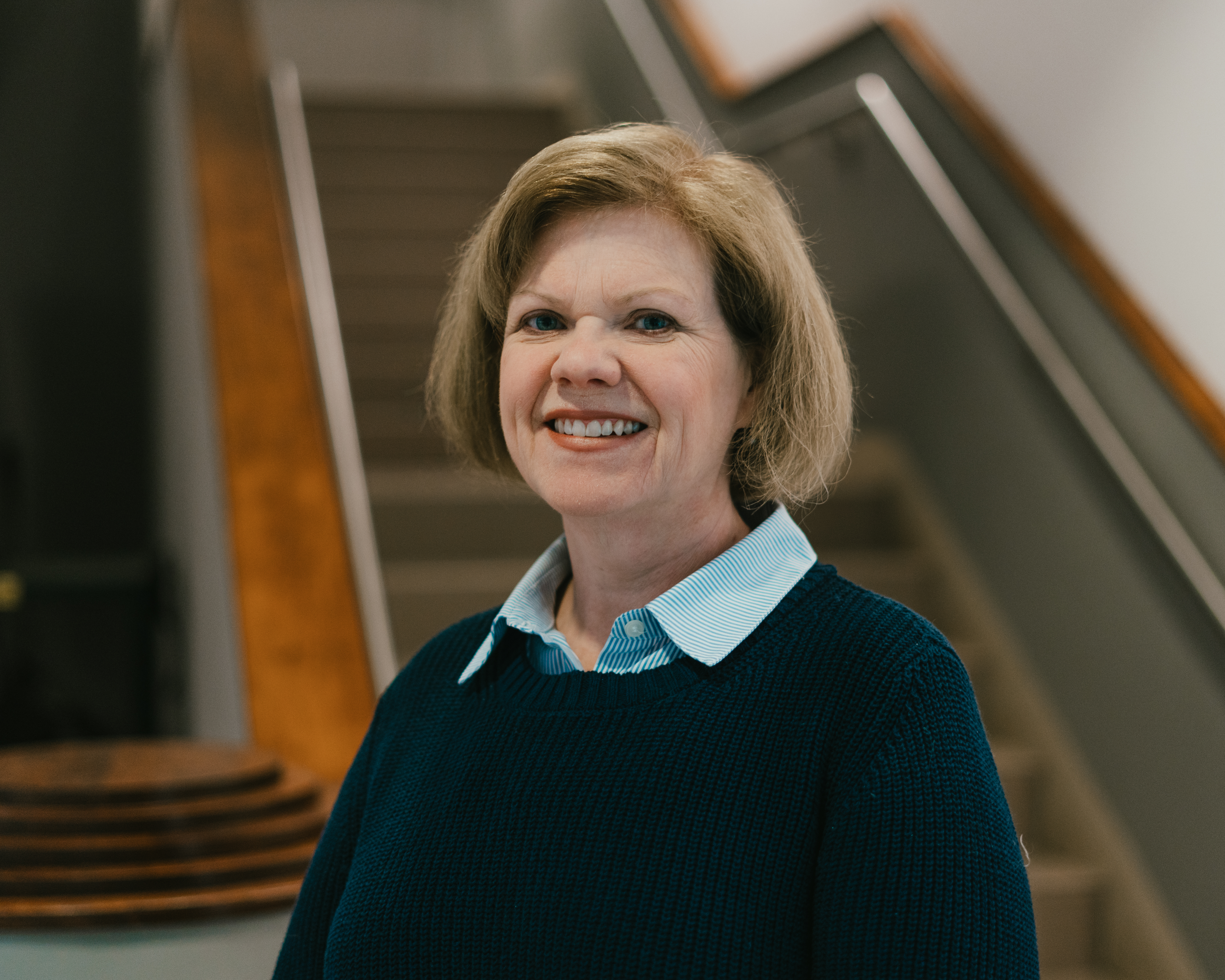 Dr. Asbury poses in the lobby of the School of Arts and Letters