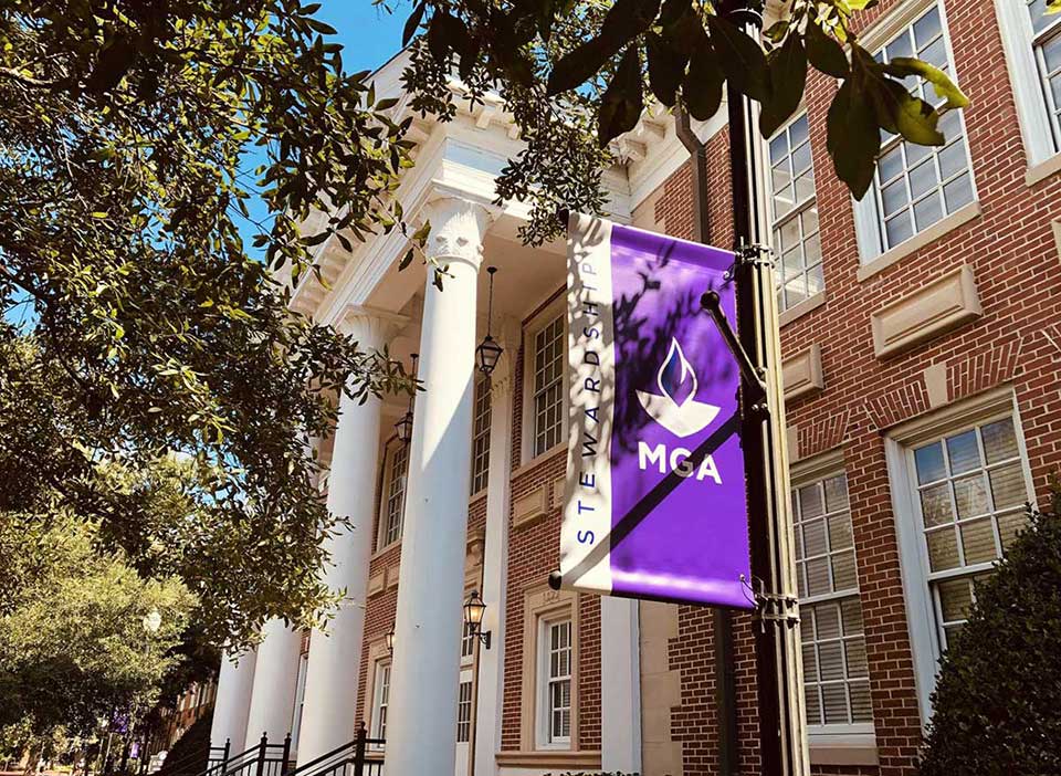 Outside Picture of Sanford Hall on the Cochran campus with MGA's Stewardship Flag on a pole